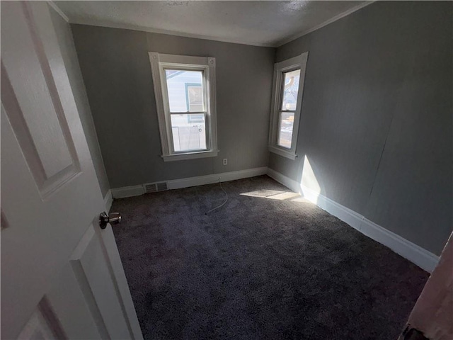 carpeted spare room with visible vents and baseboards