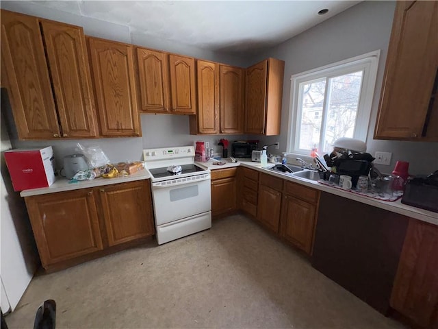 kitchen featuring a sink, brown cabinets, light countertops, and white electric range oven