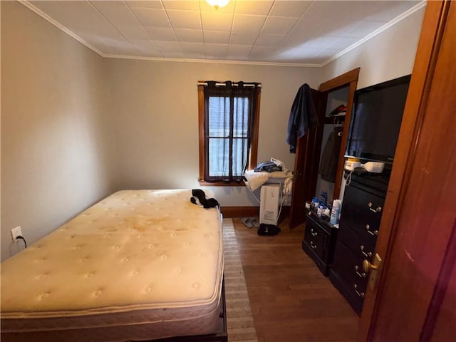 bedroom featuring crown molding, baseboards, and dark wood-style flooring