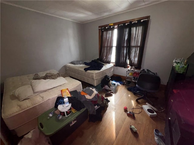 bedroom with ornamental molding and hardwood / wood-style flooring