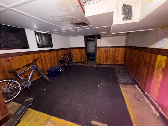 interior space with a wainscoted wall and wooden walls