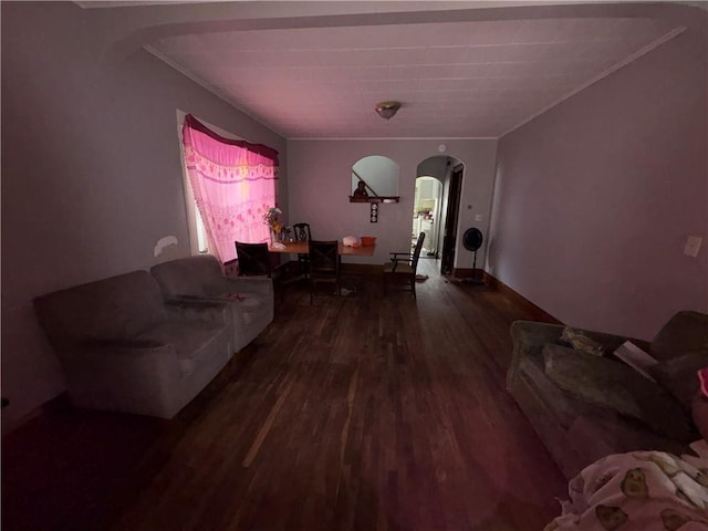 living area with arched walkways, dark wood-style floors, crown molding, and baseboards