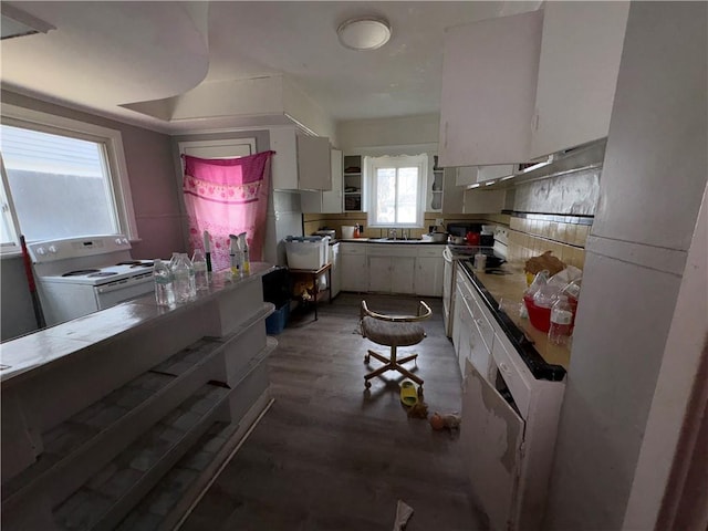 kitchen with white range with electric cooktop, a sink, range with electric stovetop, white cabinetry, and decorative backsplash