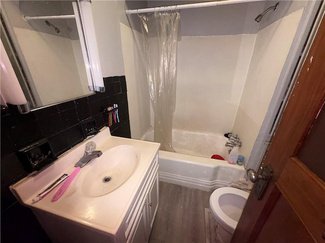 full bath featuring backsplash, toilet, shower / tub combo, wood finished floors, and vanity