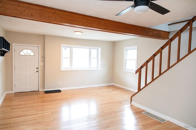 foyer entrance with baseboards, visible vents, stairway, beamed ceiling, and light wood-style floors