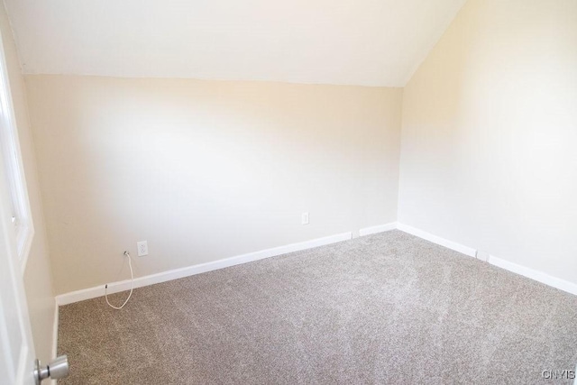 unfurnished room featuring lofted ceiling, carpet, and baseboards