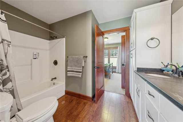 full bathroom featuring toilet, wood finished floors, vanity, baseboards, and shower / bathtub combination with curtain