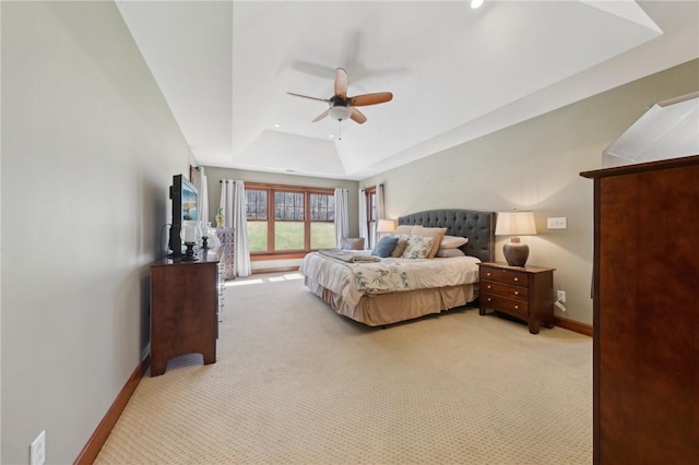 bedroom with baseboards, a tray ceiling, a ceiling fan, and light colored carpet