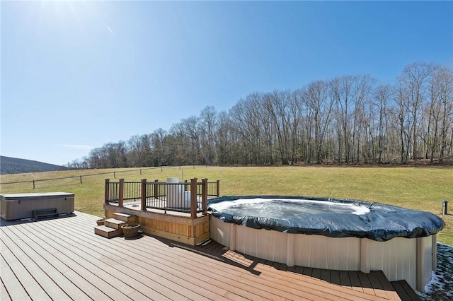 deck featuring a yard and a hot tub