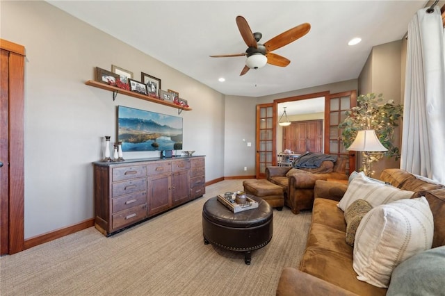 living room featuring light carpet, ceiling fan, baseboards, and recessed lighting