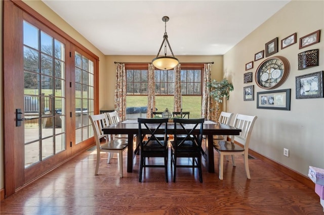 dining space featuring a healthy amount of sunlight, baseboards, and wood finished floors