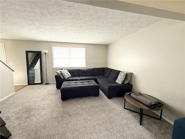 living area with a textured ceiling, carpet flooring, and baseboards