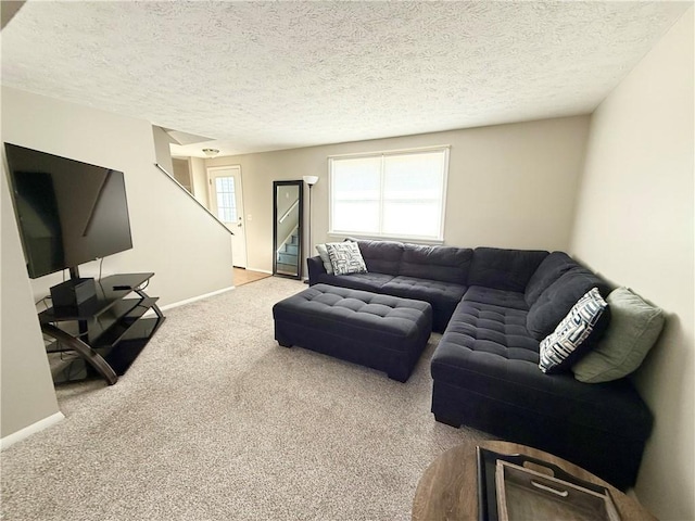 carpeted living area featuring a textured ceiling, baseboards, and stairs