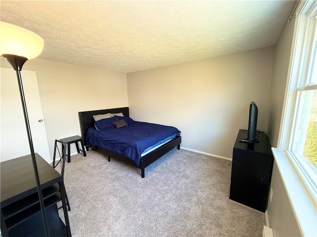 carpeted bedroom with multiple windows, baseboards, and a textured ceiling