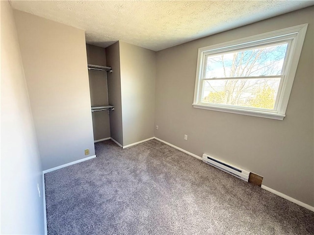 unfurnished bedroom with carpet floors, baseboards, a baseboard heating unit, and a closet