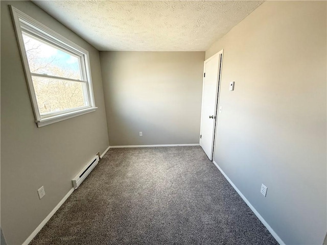 carpeted empty room with baseboards, baseboard heating, and a textured ceiling