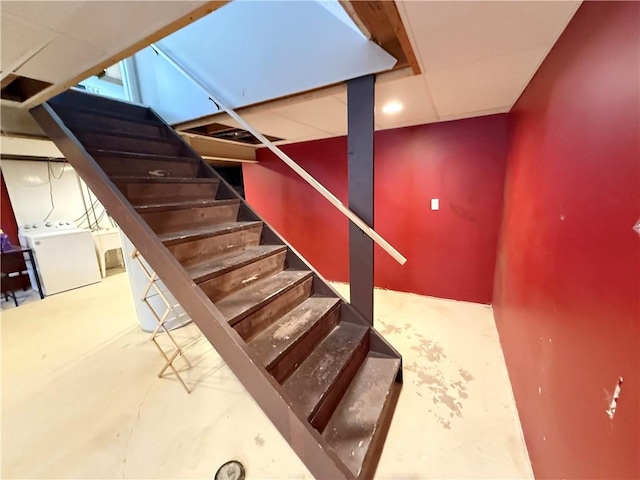 stairs with concrete flooring and washer / clothes dryer