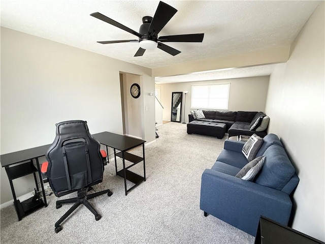 carpeted office space featuring a textured ceiling, ceiling fan, and baseboards