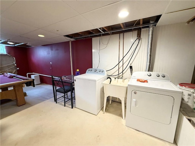 clothes washing area with laundry area, independent washer and dryer, and a sink