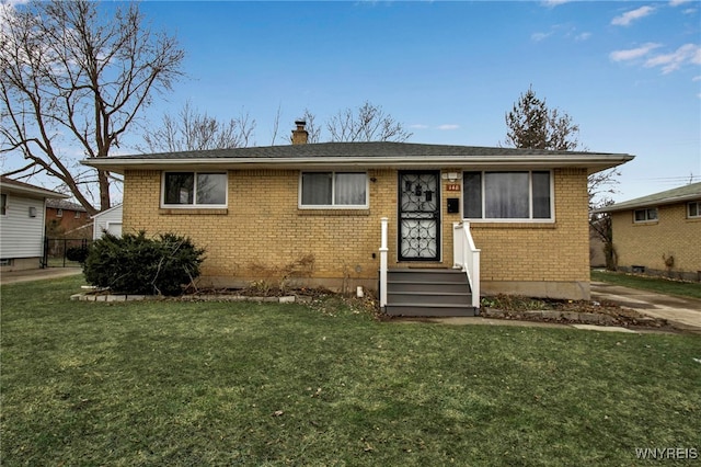 view of front of property featuring a front lawn, a chimney, and brick siding