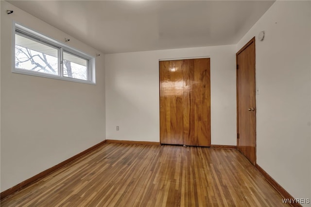 unfurnished room featuring baseboards and wood finished floors