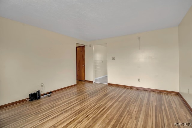 empty room with light wood finished floors and baseboards