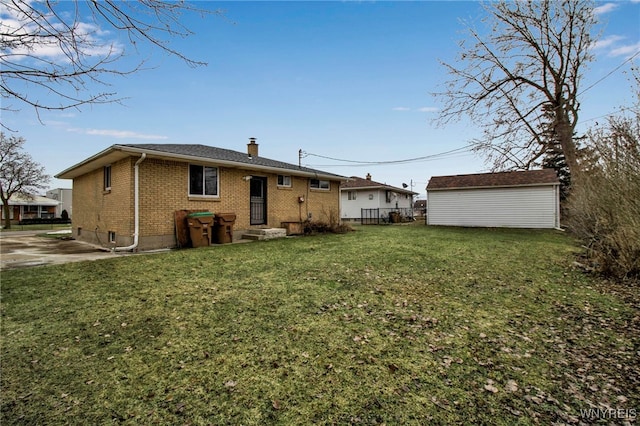 back of house with an outbuilding, brick siding, a yard, a chimney, and a storage unit