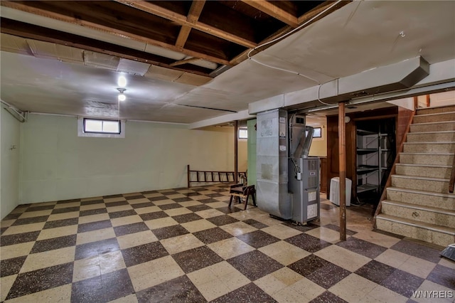 basement featuring heating unit, stairway, and tile patterned floors