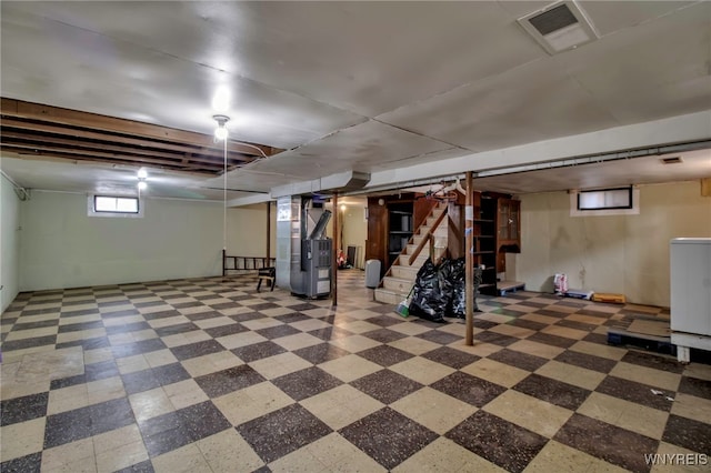 below grade area with washer / dryer, visible vents, heating unit, and stairs