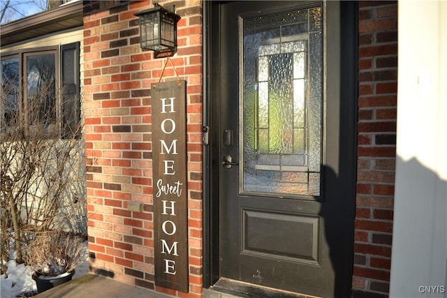 doorway to property featuring brick siding