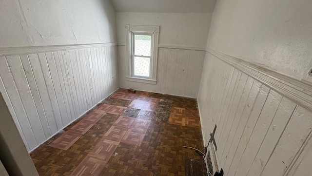 hallway featuring wainscoting and wood walls