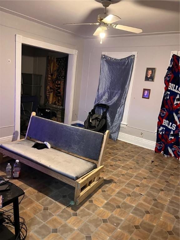 bedroom with stone finish floor, ceiling fan, and baseboards