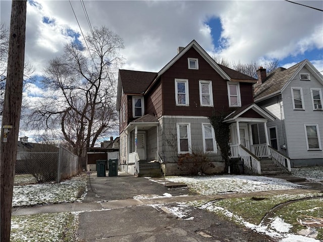 view of front of house featuring roof with shingles and fence