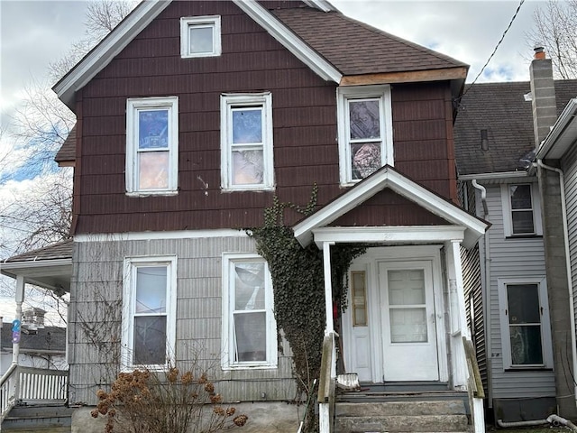 view of front facade featuring entry steps and roof with shingles