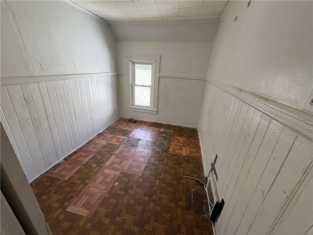 corridor featuring wainscoting and wooden walls