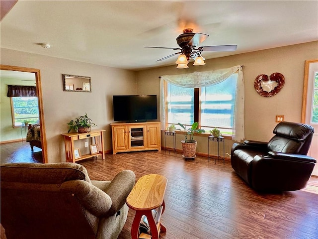 living room featuring dark wood-style floors, baseboards, and a ceiling fan