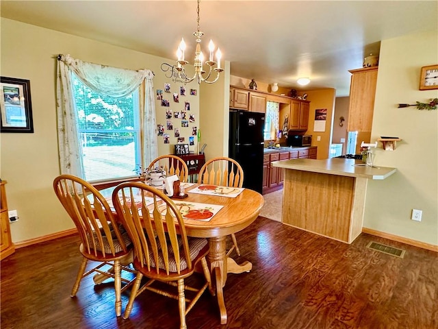 dining space featuring an inviting chandelier, baseboards, visible vents, and wood finished floors