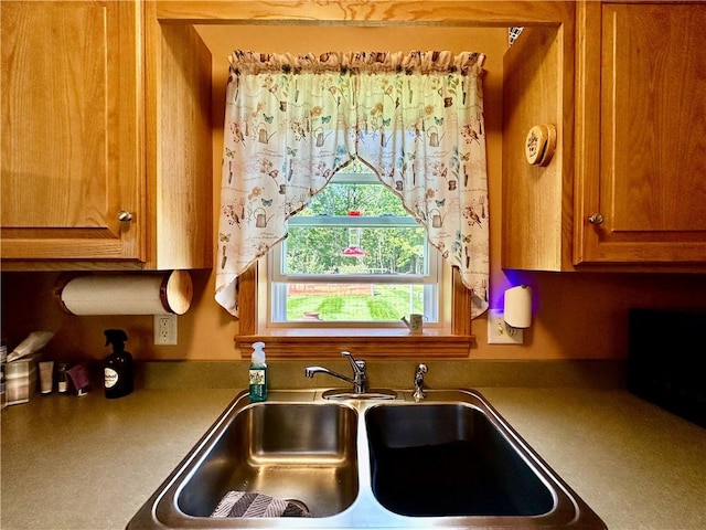 kitchen featuring brown cabinets and a sink