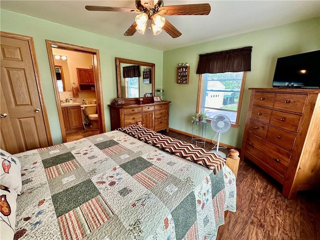 bedroom with ceiling fan, ensuite bath, wood finished floors, and baseboards