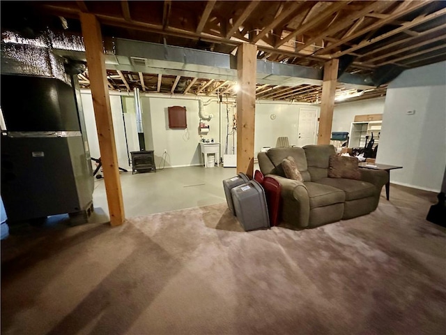 unfinished basement with a wood stove and heating unit