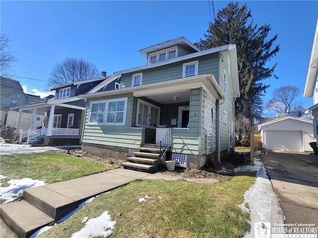 american foursquare style home with covered porch, a garage, an outdoor structure, driveway, and a front yard