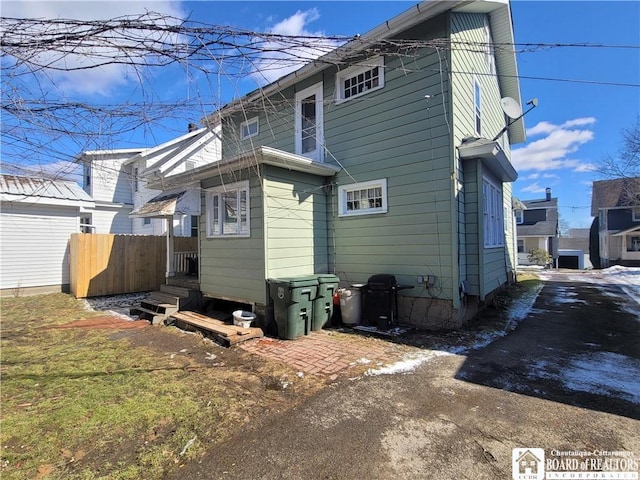 rear view of house featuring fence