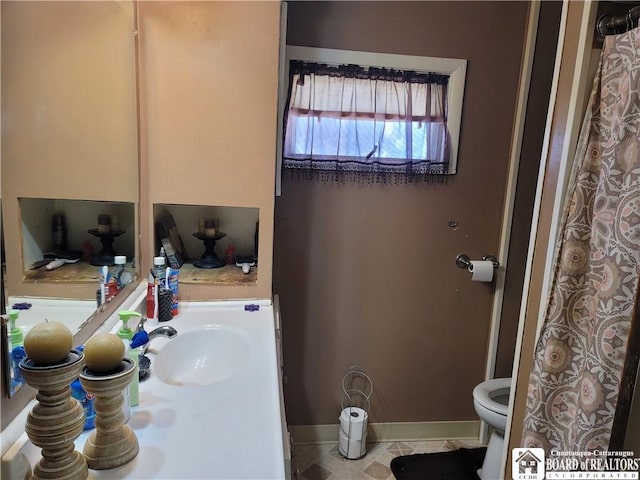 full bath with toilet, baseboards, and vanity