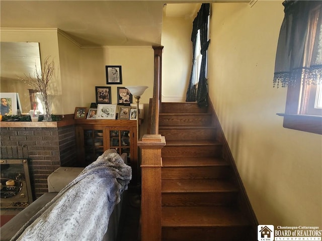 stairs featuring ornamental molding, a brick fireplace, and baseboards