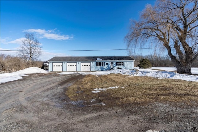 view of front of property featuring dirt driveway and an attached garage