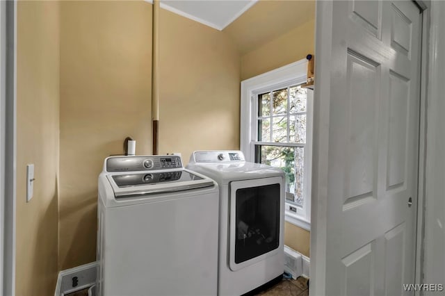 clothes washing area with laundry area, baseboards, and separate washer and dryer