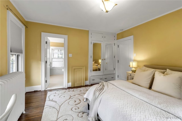 bedroom featuring radiator, dark wood-style floors, baseboards, and crown molding