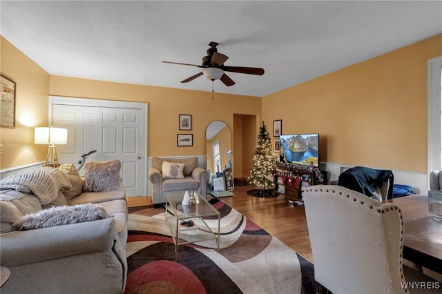 living room featuring wainscoting, ceiling fan, and wood finished floors