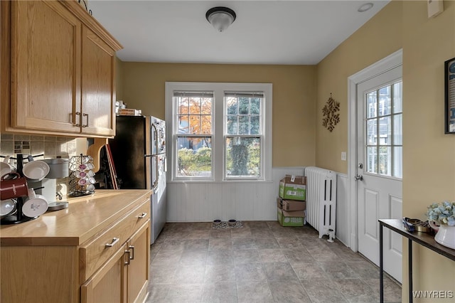 doorway featuring wainscoting and radiator