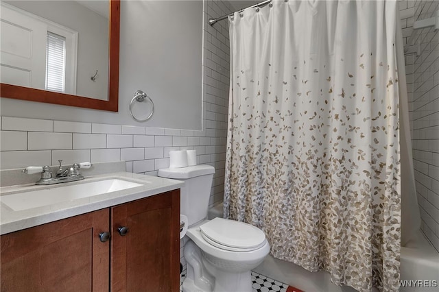 full bath with toilet, vanity, shower / bath combo with shower curtain, and tile walls